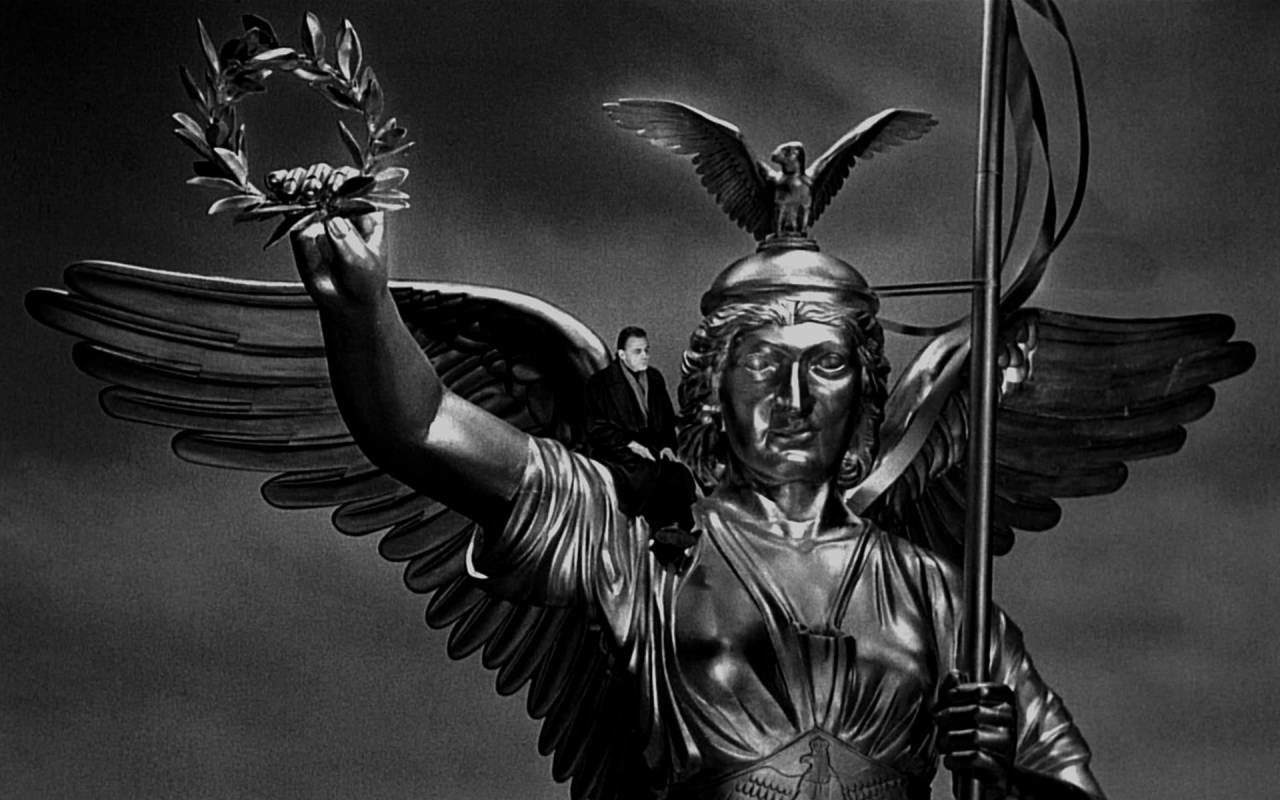 Damiel (Bruno Ganz) sits atop the Berlin Victory Column in Wings of Desire (1987)