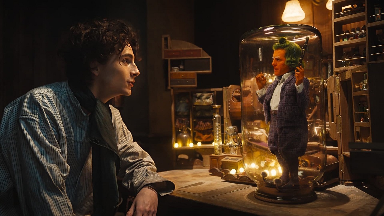 Willy Wonka (Timothee Chalamet) and Oompa-Loompa Hugh Grant in Wonka (2023)